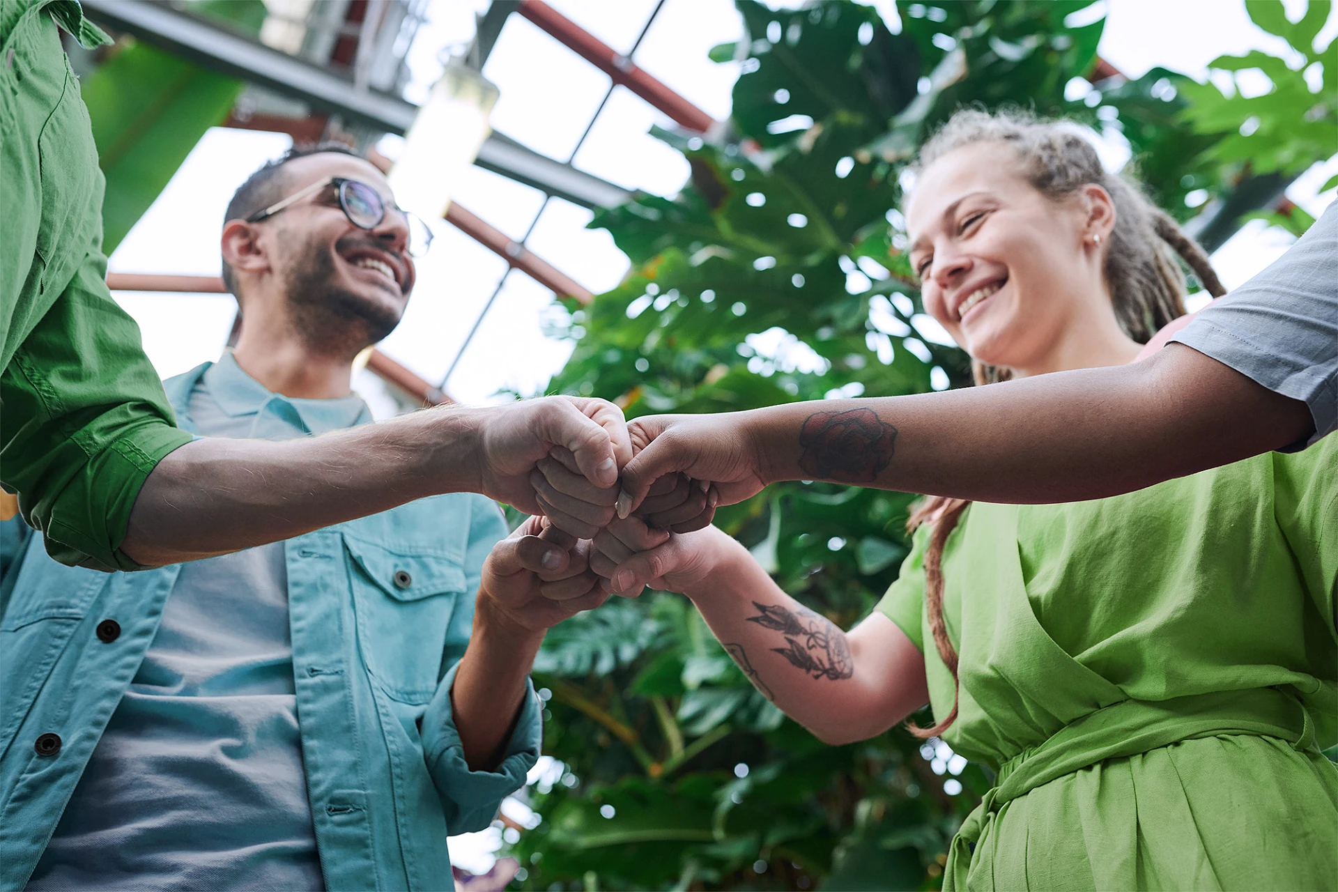 Vielseitiges Community Management Vier Personen stossen Fäuste aneinander mit Freude